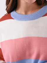 Buzo multicolor de punto con rayas en tonos rosa, azul y terracota, de corte holgado.