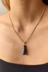 Collar dorado con cadena fina y dije colgante en forma de lágrima de piedra natural azul con vetas blancas.