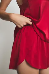 Conjunto de pijama de satén rojo, compuesto por un top con breteles finos y detalle de encaje en el escote, y un short con cintura elástica.