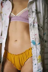 Bombacha de lycra lila con estampado de flores y volados en los bordes.