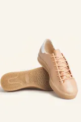 Zapatillas bajas blancas de cuero vacuno con detalle de refuerzo de gamuza color borgoña en el talón y suela de goma color caramelo.