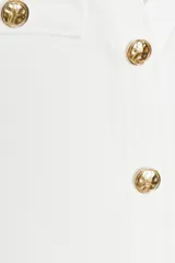 Vestido corto blanco de sarga, con escote en V, sin mangas, bolsillos frontales con botón dorado y cierre frontal con botones metálicos dorados en relieve.