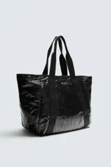 Bolso tipo shopper negro con acabado metalizado. Tiene un compartimento principal con cierre de cremallera y un bolsillo interior de malla con cremallera.