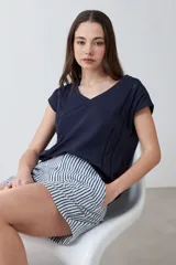 Remera color durazno con escote en V y detalle de vainillas en los laterales. De manga corta y corte recto.