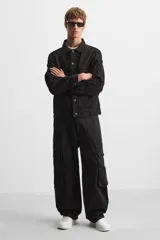 Zapatilla deportiva negra de estilo retro con suela de goma con volumen.