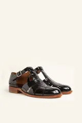 Sandalias de cuero color marrón claro, con diseño de tiras entrecruzadas y hebilla lateral.