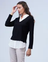 Buzo de hilado fino color beige con cuello y ruedo de gasa blanca que simula una camisa debajo. Presenta escote en V y mangas largas.