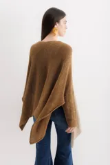 Poncho color beige de algodón tejido, con moldería oversize y tajos en los laterales.
