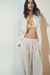 Pantalón palazzo blanco de lino, de tiro alto con cintura elástica ajustable con lazada.