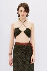 Top crop negro con estampado floral en tonos ocre y verde, con breteles finos y espalda descubierta.