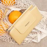 Billetera larga color camel, con textura símil cuero, cierre de broche en solapa frontal y correa de mano desmontable.