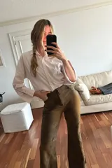 Pantalón oxford de cuero ovino color marrón con efecto desgastado y botón en guampa.