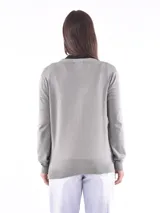 Saco de tejido de punto color beige, con cuello en V y cierre frontal con botones.