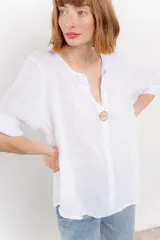 Blusa celeste de lino, con escote en V, manga tres cuartos y botón de madera.