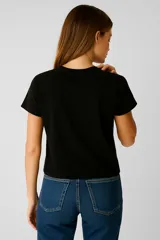 Remera negra de algodón con estampado de flores azules y texto "Let Love In".