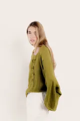 Blusa color rosa pálido de lino con mangas amplias y detalle de costuras en el frente.