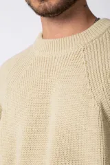 Sweater marrón de punto con cuello redondo y mangas largas raglán. Tejido grueso con textura acanalada. Corte holgado.