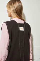 Enterito de jean color chocolate, con botones delanteros, bolsillos laterales y pespunte blanco.