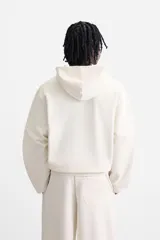 Sudadera con capucha gris confeccionada en tejido de algodón con interior rizo. Tiene manga larga, bolsillo frontal tipo canguro y acabados en rib.