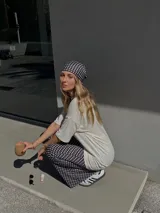 Pantalón palazzo negro con lunares blancos, confeccionado en viscosa.