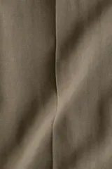 Pantalón tobillero color verde oliva de corte holgado, tiro alto, con elástico oculto en la cintura, cierre con botón, bolsillos al bies y bolsillos decorativos atrás. Presenta pliegues de tabla adelante, pinzas en la parte posterior y piernas amplias con raya adelante y atrás.