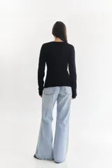 Sweater entallado color crema con textura tejida en relieve.
