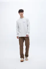 Buzo celeste de felpa liviana con cuello redondo, puños en mangas y bajo holgado. Tiene un bordado pequeño en el pecho con la inscripción "Uniform St.".