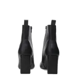 Botas de caña corta en color blanco con punta cuadrada y taco bloque. Cuentan con un detalle en contraste negro en la parte interna del taco y un tirador posterior para facilitar el calce.