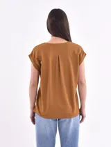 Blusa blanca de corte holgado, con cuello en V y mangas cortas.