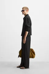 Pantalón negro de corte recto con cintura elástica, bolsillos laterales y un bolsillo trasero de ojal.