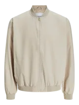 Campera bomber color beige de Jack & Jones, con cuello baseball, cierre frontal con cremallera, bolsillos delanteros y puños de canalé.