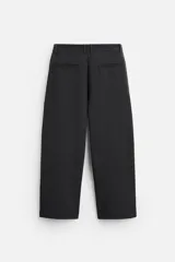 Pantalón relaxed fit color verde oscuro, con pliegues en la parte delantera, bolsillos laterales y traseros de ojal. Cierre frontal con cremallera y botón.