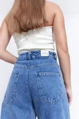 Top strapless color verde oliva, con drapeado estructurado y diseño de nudo frontal.