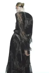 Vestido largo negro con estampado paisley, escote en pico, mangas largas acampanadas con volantes y cintura elastizada con cordón ajustable.