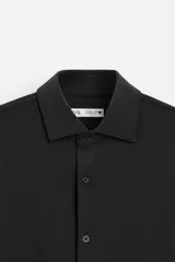 Camisa azul marino slim fit de manga larga con cuello italiano abierto y cierre frontal con botones.