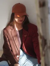 Blazer oversize con diseño asimétrico que combina dos tweeds contrastantes: uno marrón liso y otro blanco y negro con estampado pata de gallo. Tiene botones de strass y un pin de salchicha.