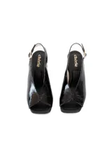 Zapato de charol negro con escote en el empeine y tacón cuadrado.