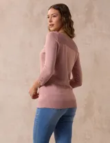 Buzo rosa de tejido combinado, con cuello redondo y mangas 3/4 con detalle de botones.