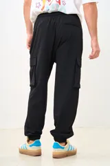Pantalón cargo negro de corte ancho con bolsillos laterales con cierre y cintura ajustable con cordón.
