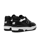 Championes de deporte color negro, con detalle de la marca en el lateral y suela blanca.
