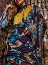 Falda larga de tul estampada con motivos paisley en tonos azul, naranja y marrón. Tiene drapeado en la cadera, corte evasé y cintura elástica.