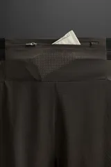 Shorts deportivos color marrón confeccionados en tejido técnico ligero y elástico. Cuenta con cintura elástica ajustable con cordón interior, bolsillos frontales, bolsillo trasero con cierre de cremallera, forro interior y bajo con aberturas laterales.