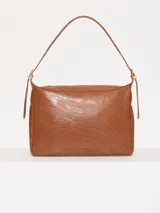 Cartera hobo color marrón confeccionada en cuero vacuno flor, con acceso mediante cierre superior y correa regulable con hebillas metálicas.