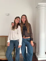 Pantalón de jean azul oscuro, de corte ancho y tiro bajo. Presenta cierre y botón en la parte delantera, bolsillos delanteros con detalle de encaje, bolsillo trasero y presillas para cinturón.