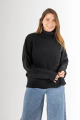 Sweater negro tejido en punto arroz, con cuello alto, mangas largas y silueta holgada.
