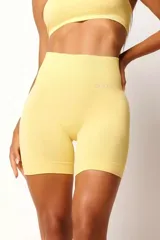 Short deportivo color amarillo, de tiro alto y corte ajustado. Confeccionado con tecnología seamless y textura acanalada en la cintura.