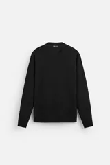 Jersey negro de punto fino, con cuello redondo y manga larga.