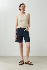 Bermuda azul marino de corte recto, con cinco bolsillos y cierre frontal con botón y cremallera.