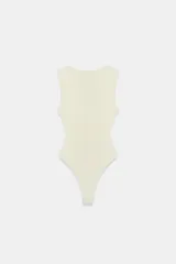 Body entallado color marrón oscuro con escote pronunciado en pico y manga sisa. Cierre en la parte inferior con botones a presión.