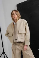 Chaqueta bomber corta color gris oscuro confeccionada en paño de lana. Tiene maxi bolsillos en la delantera con abertura lateral, pespuntes y vistas interiores a contra tono y acceso tradicional con cierre metálico.